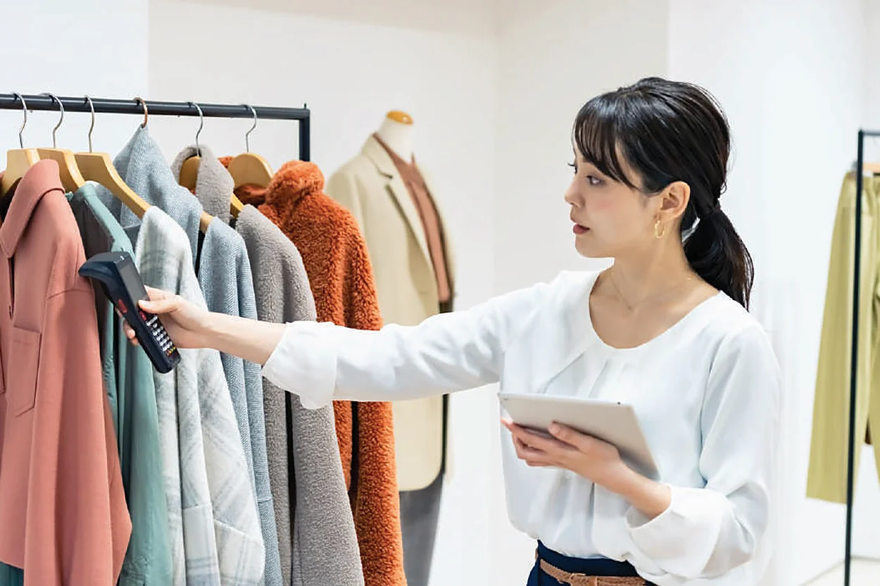Retail associate scanning garments with an RFID reader